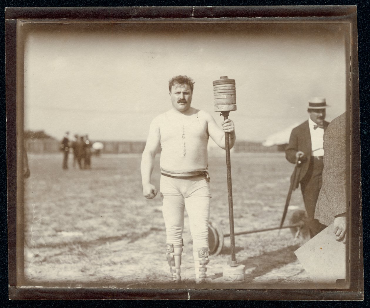 Fred Winters, competitor in the barbell contest at the 1904 Olympics posing with weights av Unknown