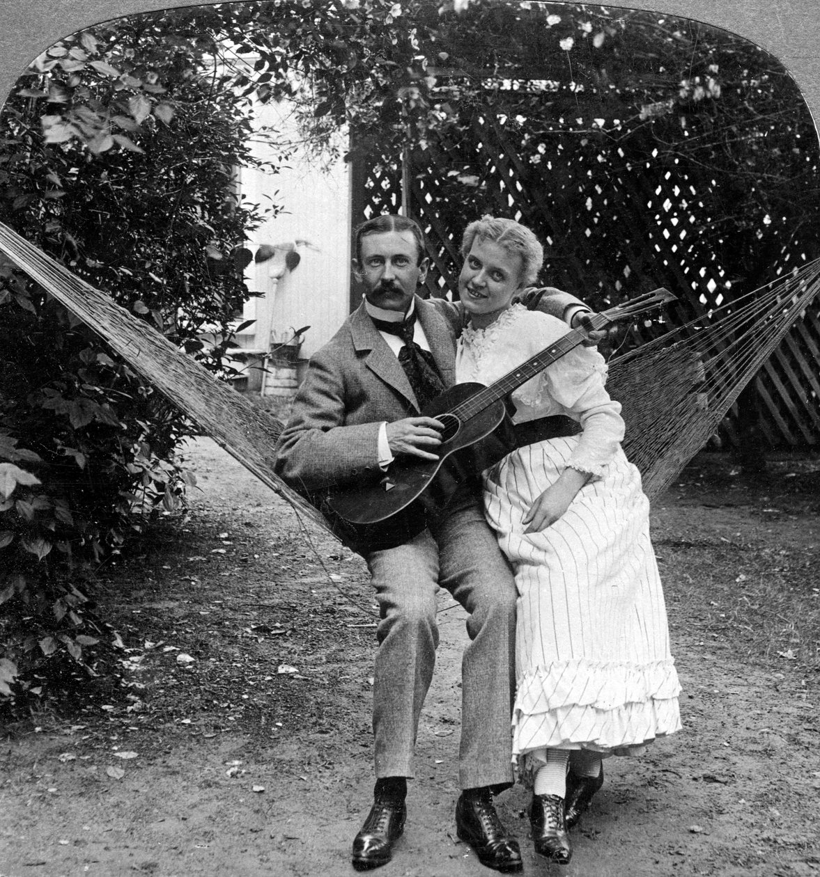 Det musikaliska paret i hängmattan. av American Stereoscopic Company