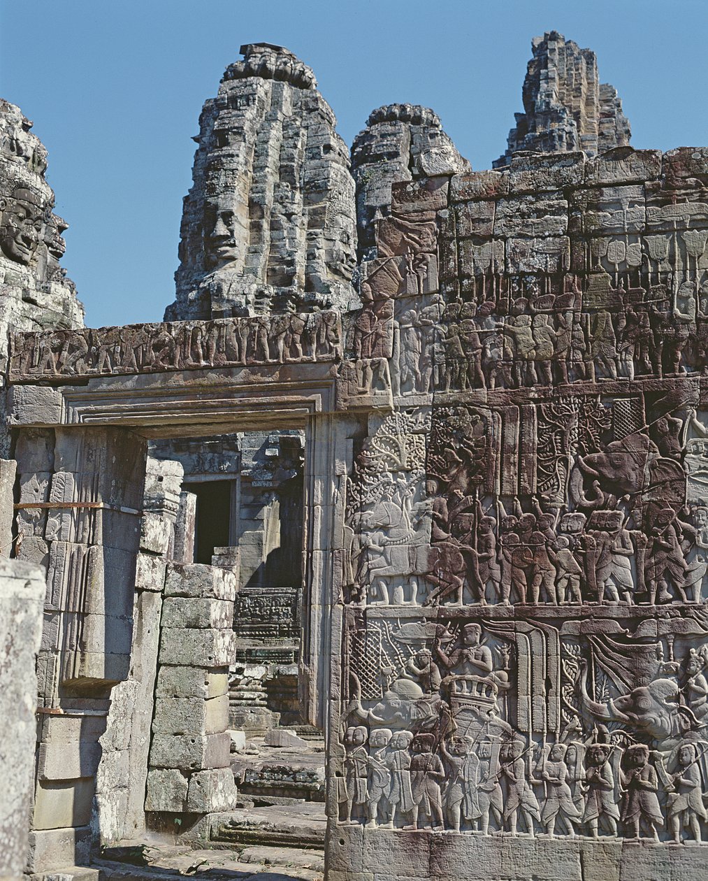 Vy över en vägg i Bayon-templet med inristade reliefer. av Cambodian School