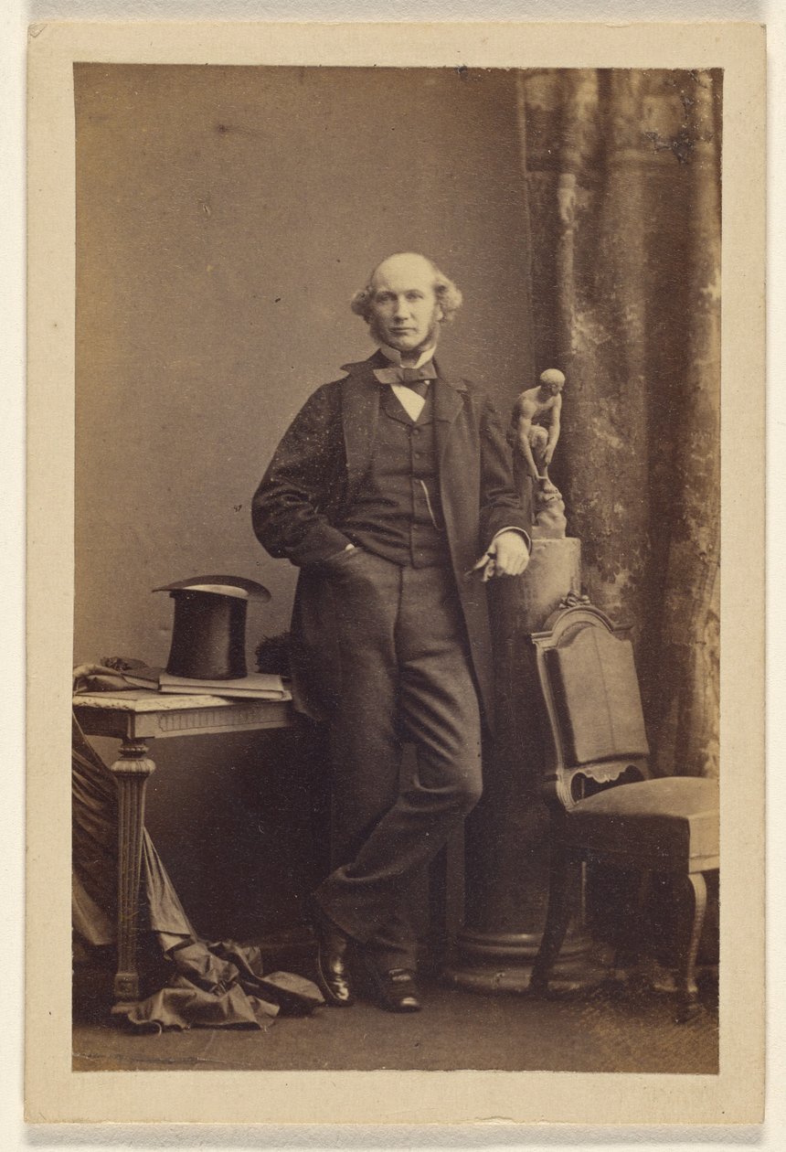 [Oidentifierad man står, hög hatt på bordet] av Camille Silvy