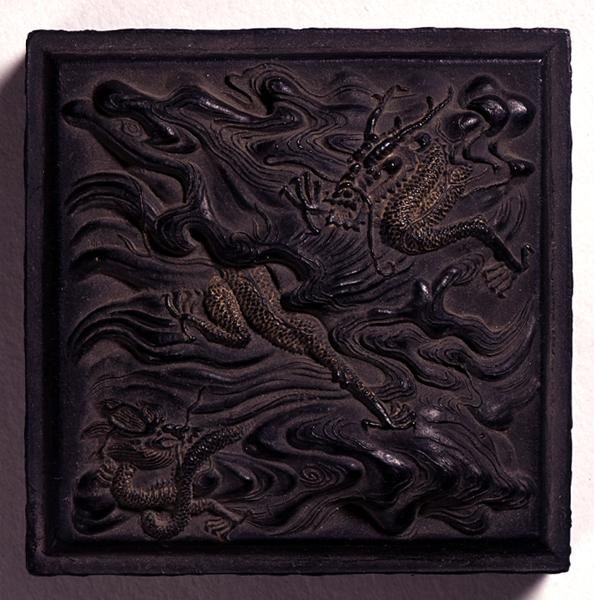 Bläckkaka i form av ett sigill med kupolformad knopp gjuten i dramatisk relief med två drakar bland vågor, tillskriven Wang Wei-kao, Ching-dynastin, Hui-chou, Anhui (ristat bläck) (se även 142689-90). av Chinese School