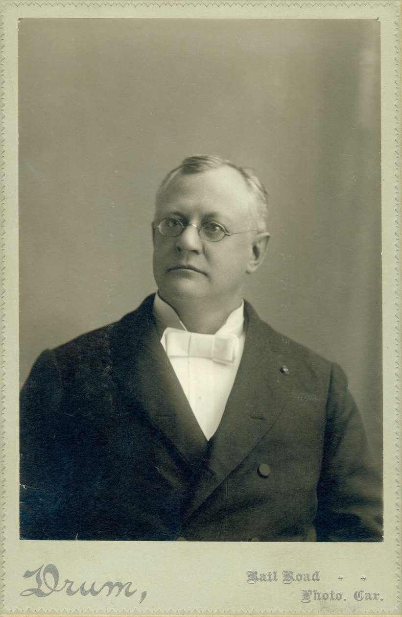 Bust portrait of Clarence W. Backus wearing a suit av Drum