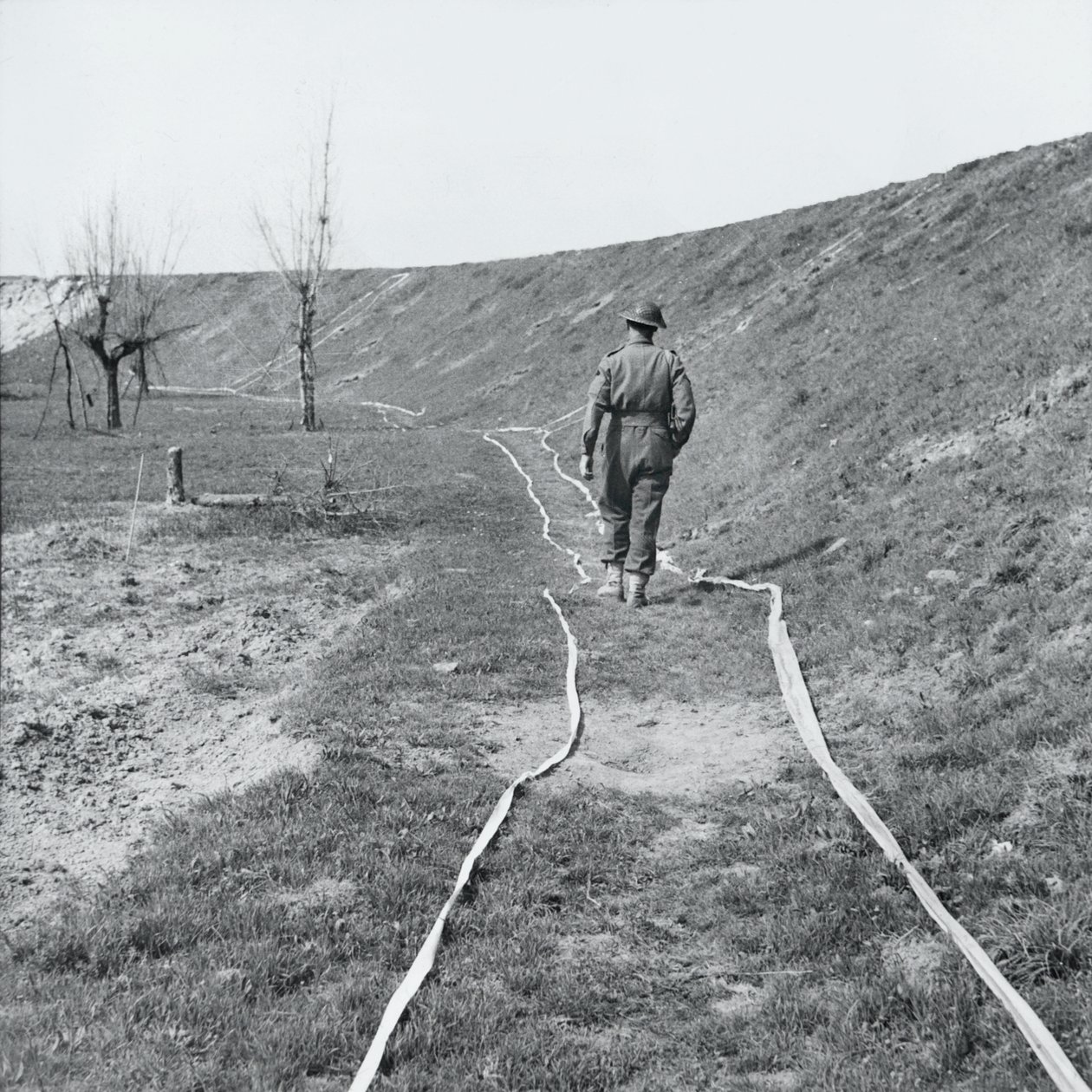 Vit band som markerar tydliga spår genom ett minfält, vid floden Senio, Italien, mars 1945 av English Photographer