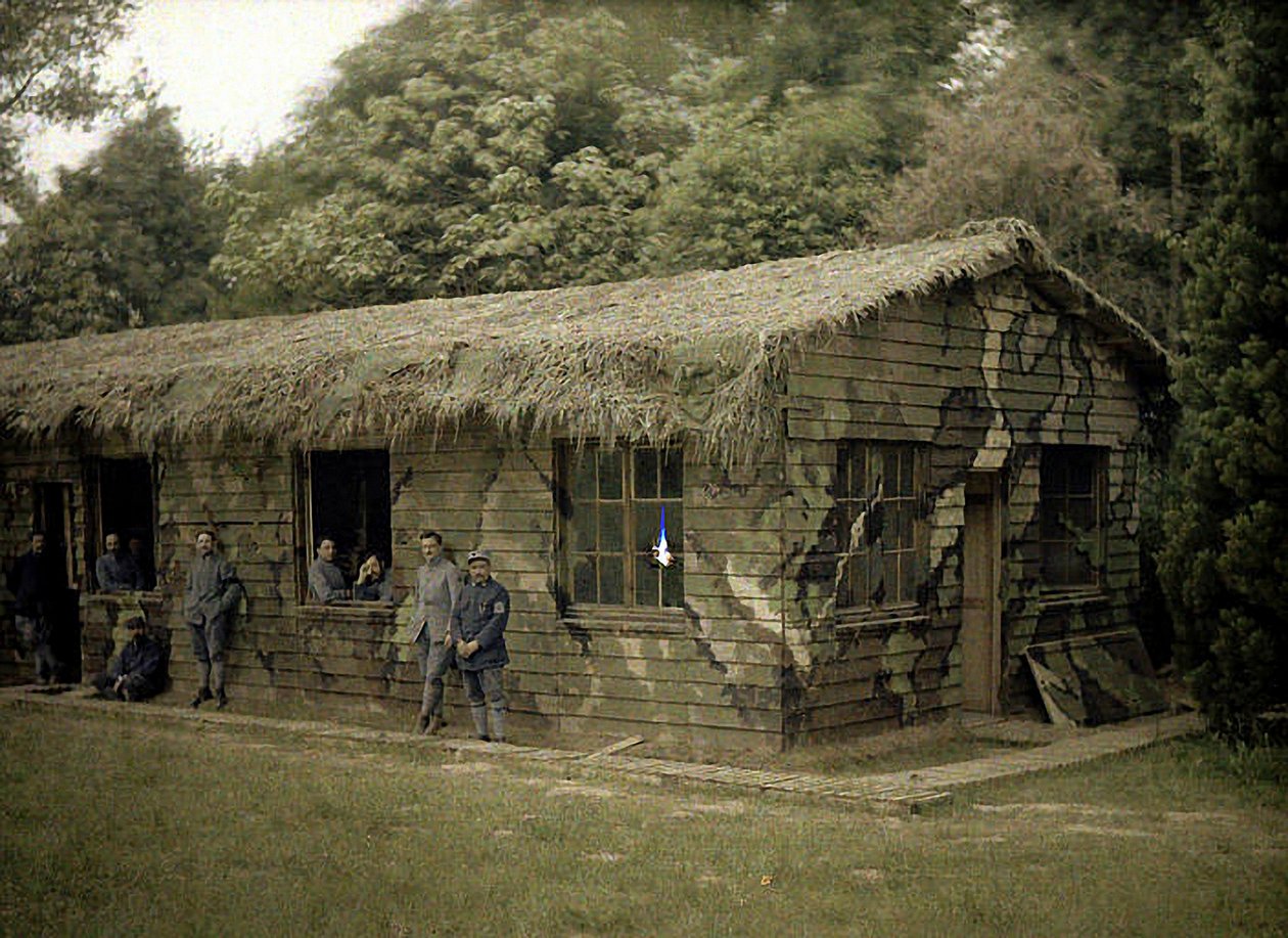 Nio franska soldater vid en träbyggnad med militärt kamouflage, Soissons, Aisne, Frankrike, 1917 (autokrom) av Fernand Cuville