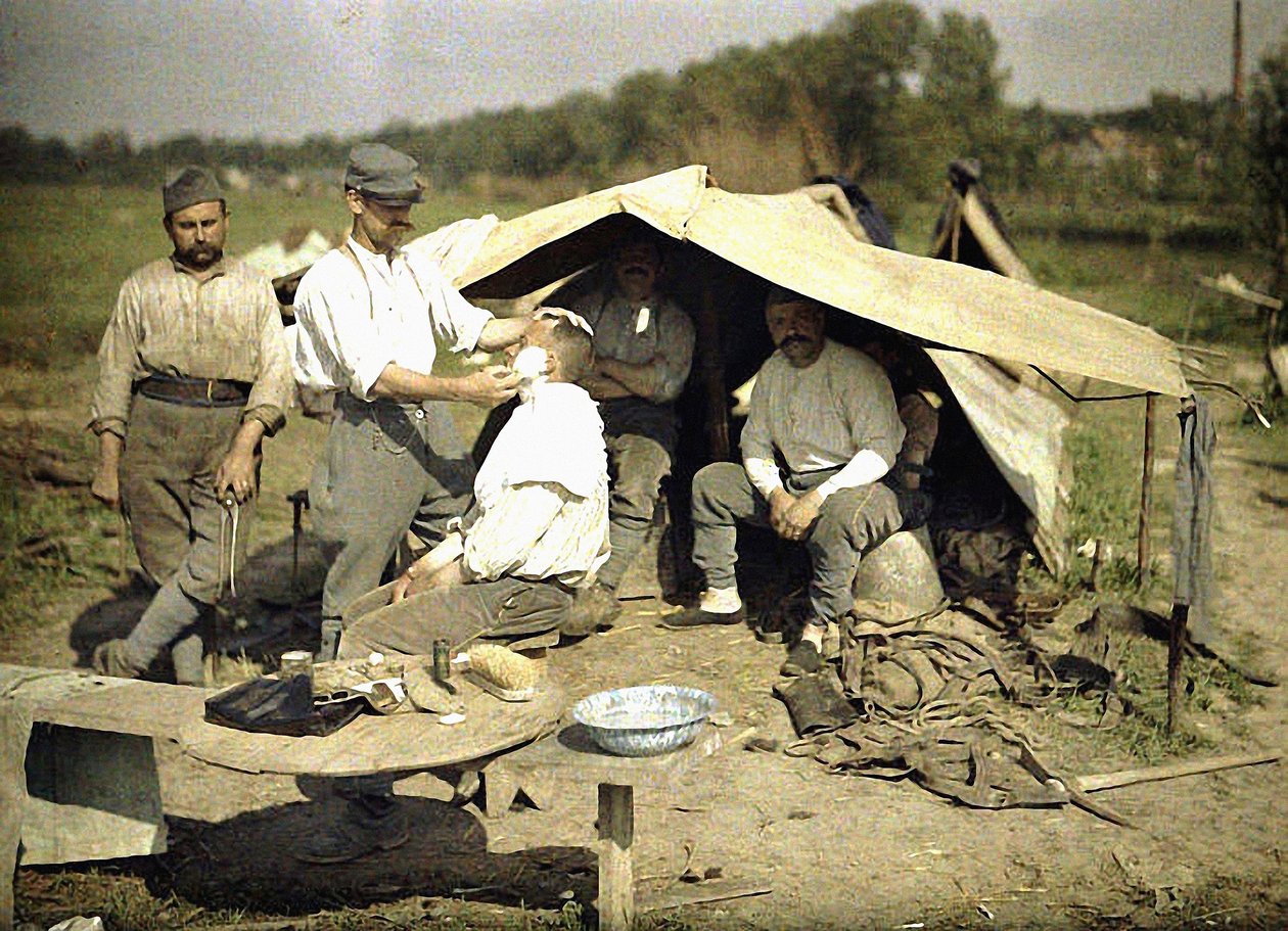 Soldat som rakas av en frisör i ett franskt militärläger, Soissons, Aisne, Frankrike, 1917 (autokrom) av Fernand Cuville