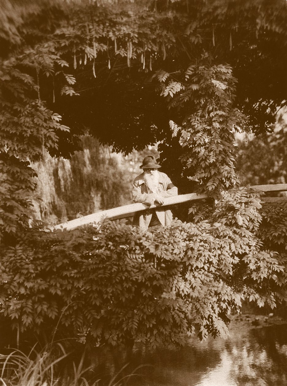 Claude Monet på den japanska bron i sin trädgård i Giverny, c.1920 av French Photographer