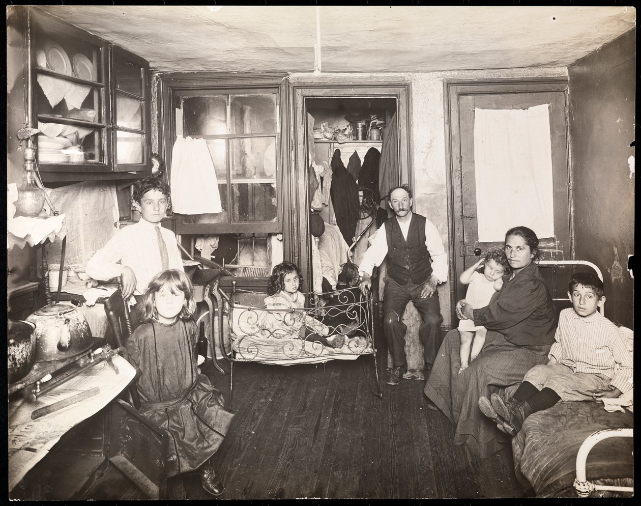 Familj i rum i hyreshus, ca 1910 (silvertryck av gelatin) av Jessie Tarbox Beals