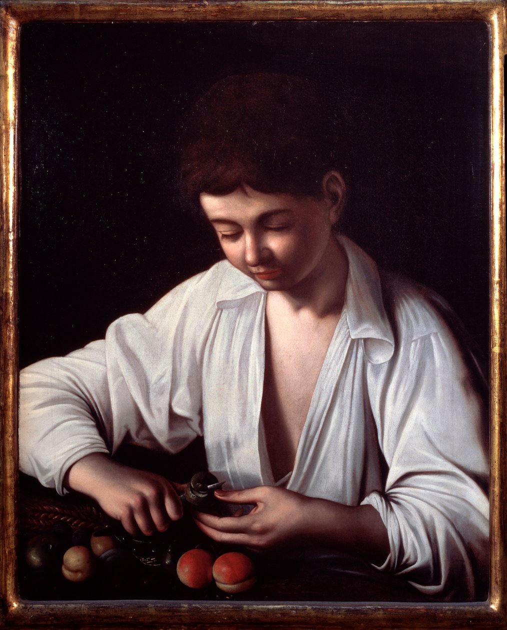 En pojke som skalar en frukt av Michelangelo Merisi da Caravaggio