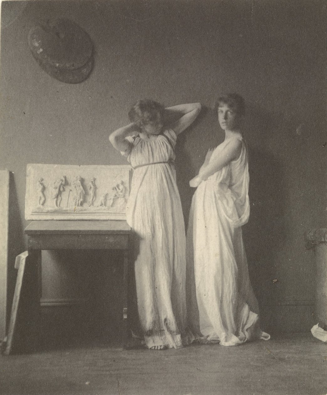 (Två kvinnliga modeller i klassisk dräkt med Eakins Sculpture Arcadia). av Thomas Eakins