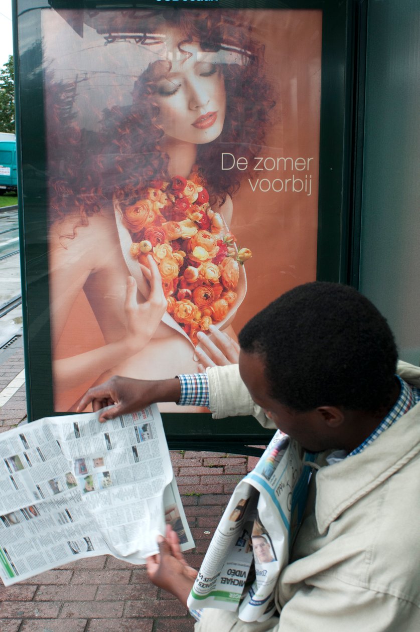 Man läser en tidning i Bryssels spårvagnshållplats i Bryssel, Belgien av Unbekannt Unbekannt
