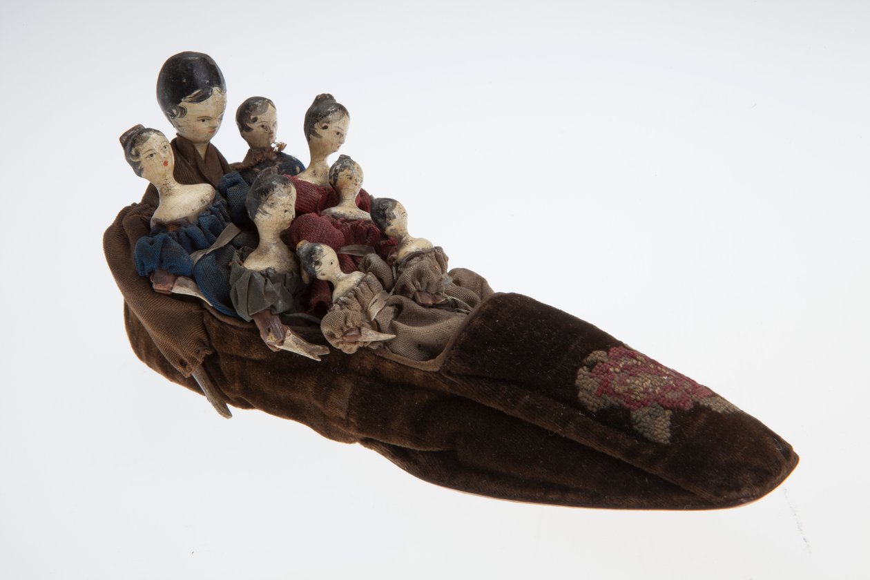 Old Woman who Lived in a Shoe toy. The toy features a velvet sliper with eight dolls inside av Unknown