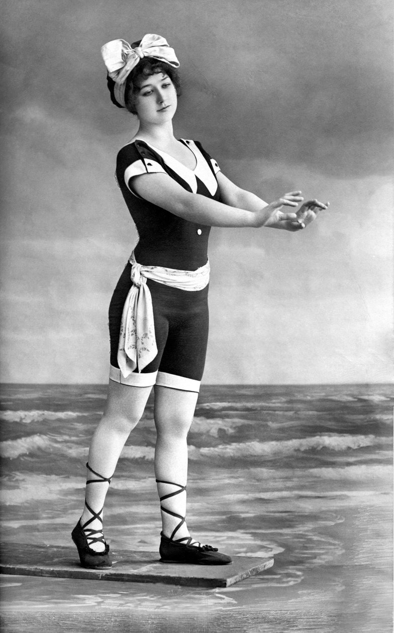 Kvinna i baddräkt och strandsko. av Unknown photographer