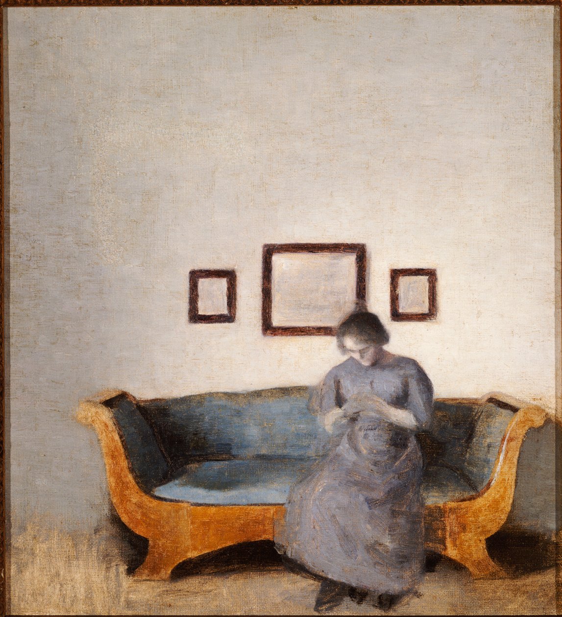 Ida Hammershoi sitter i en soffa av Vilhelm Hammershoi